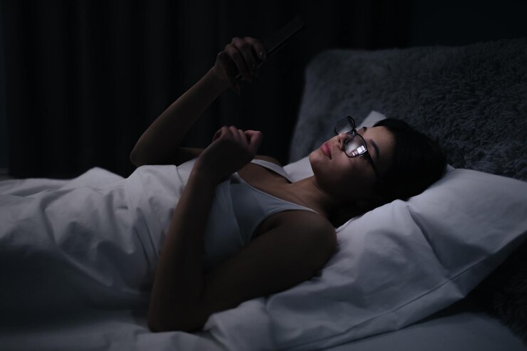 Mujer en la cama con teléfono inteligente