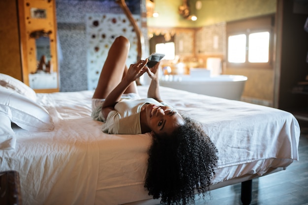 Mujer, en la cama, con, teléfono móvil