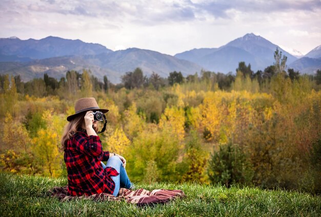 Mujer con cámara en picnic de otoño