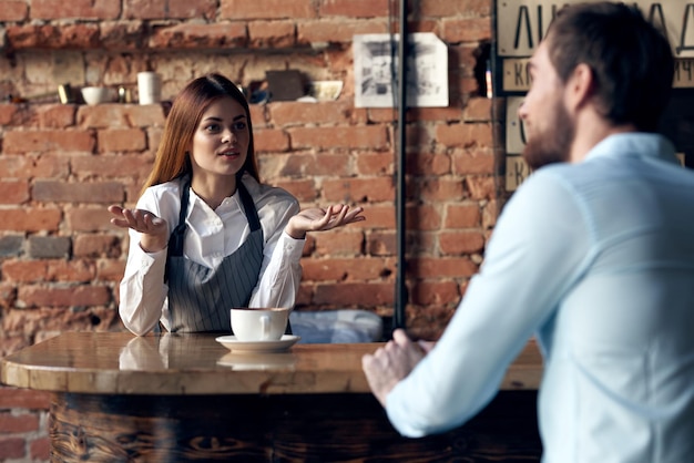 Mujer camarero trae café a un cliente de café