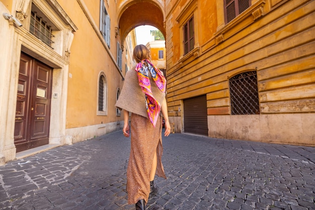 La mujer camina en la calle vieja estrecha en Roma