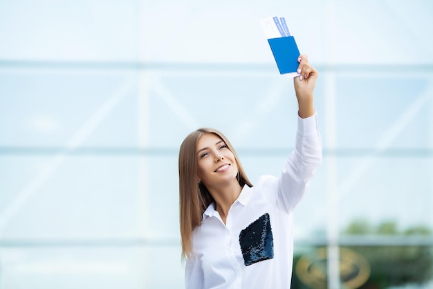 Mujer camina cerca del aeropuerto con pasaporte de maleta y boleto de pasajero