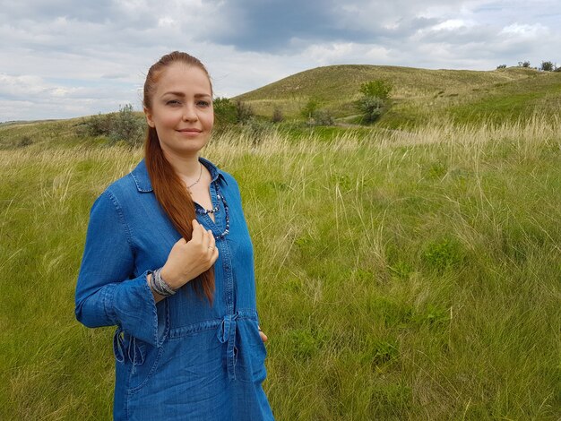 Mujer camina en un parque soleado y camina por la hierba verde