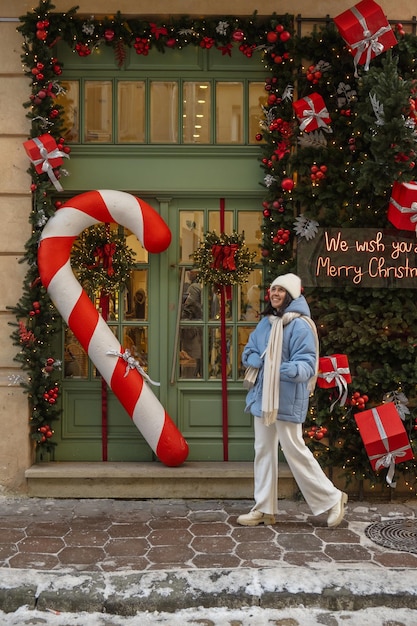 Mujer caminando por la calle de la ciudad decorada para Navidad