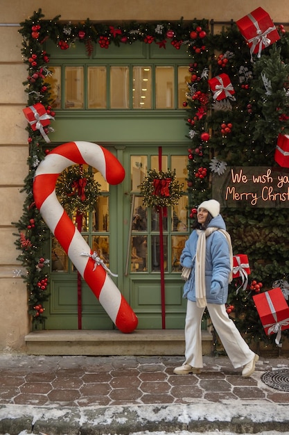 Mujer caminando por la calle de la ciudad decorada para Navidad