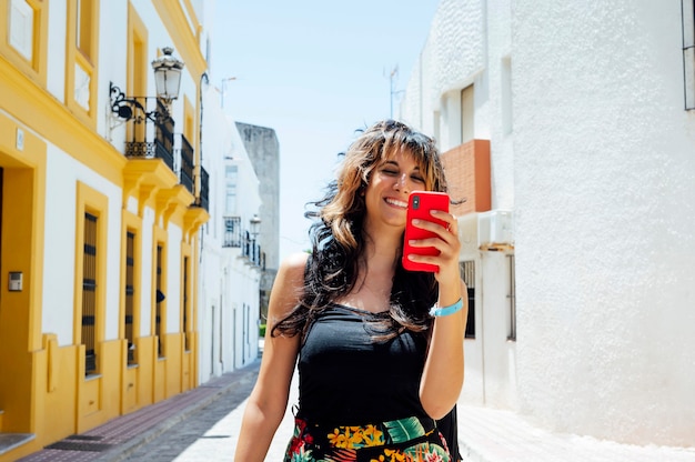 mujer caminando por la calle mirando su teléfono inteligente