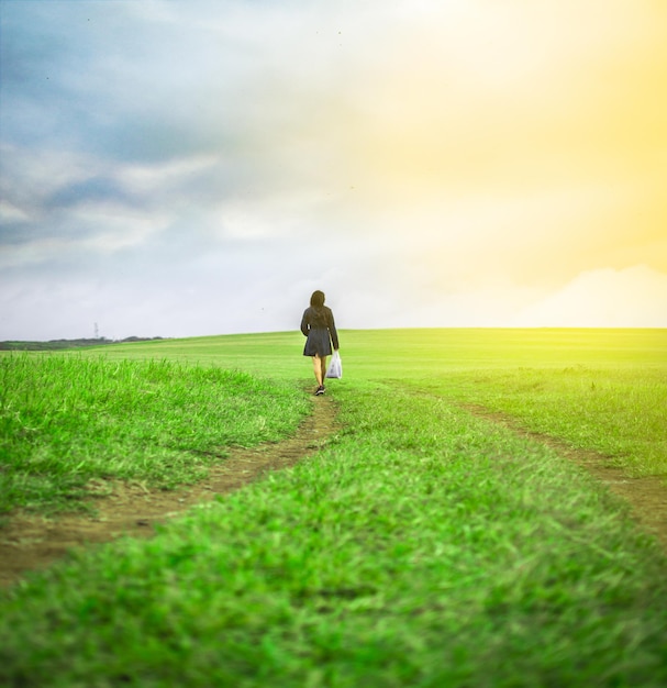 Mujer caminando en el campo con bolsas de compras mujer caminando en un camino en el campo