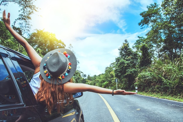 Mujer caminando por la carretera en medio de árboles contra el cielo