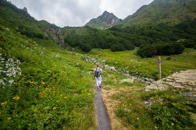 Una mujer caminando por una carretera de montaña