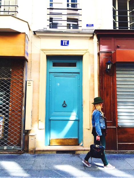 Foto mujer caminando por una casa en la ciudad