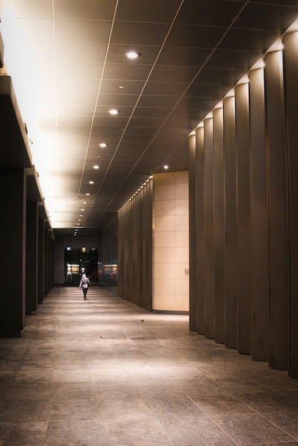 Mujer caminando por un largo pasillo por la noche