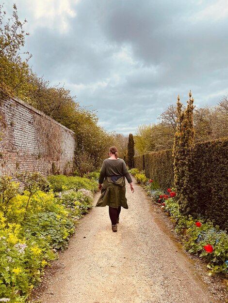 Foto mujer caminando en medio de flores