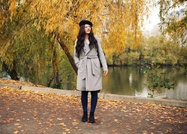 Mujer caminando en un parque de otoño