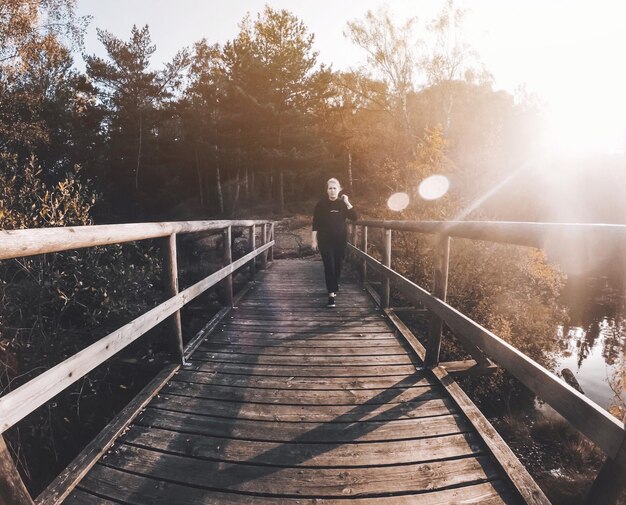 Foto mujer caminando por la pasarela durante un día soleado