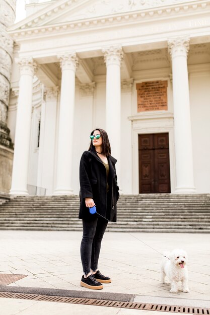 Mujer caminando con un perro en la calle