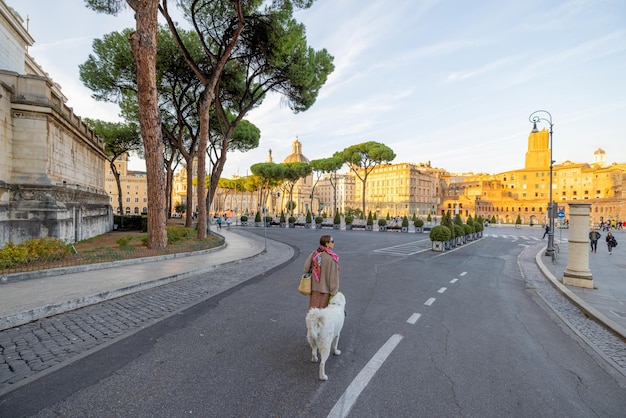 Mujer caminando con un perro en la famosa calle central de roma