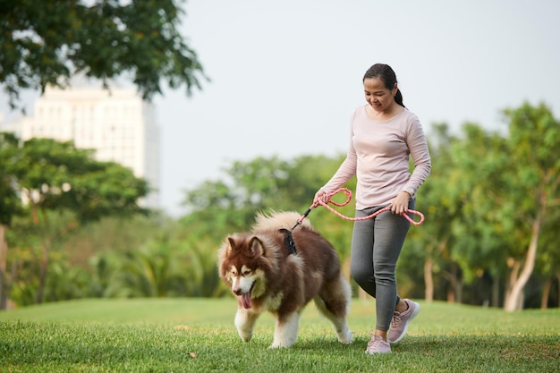 Mujer caminando con perro en el parque