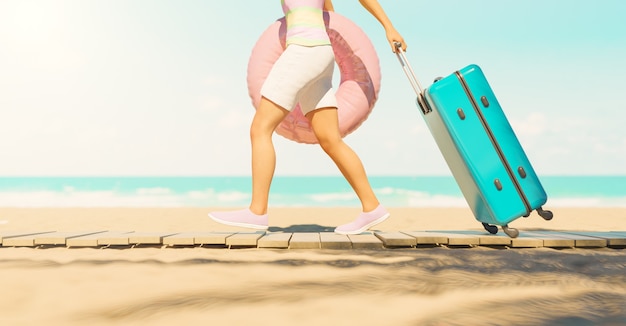 mujer caminando en la playa con maleta