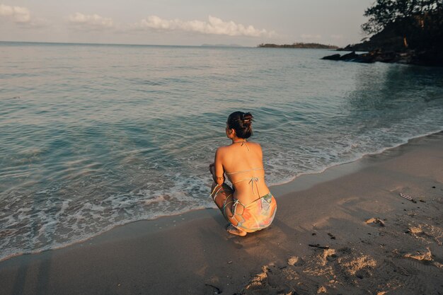 Mujer caminando por la playa por la mañana