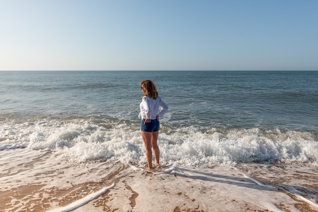 Foto mujer caminando por la playa