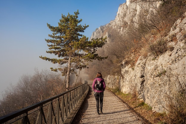 Mujer caminando sola en camino brumoso rural