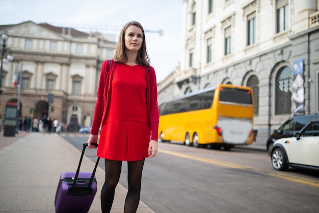 Mujer caminando con su carro en una ciudad