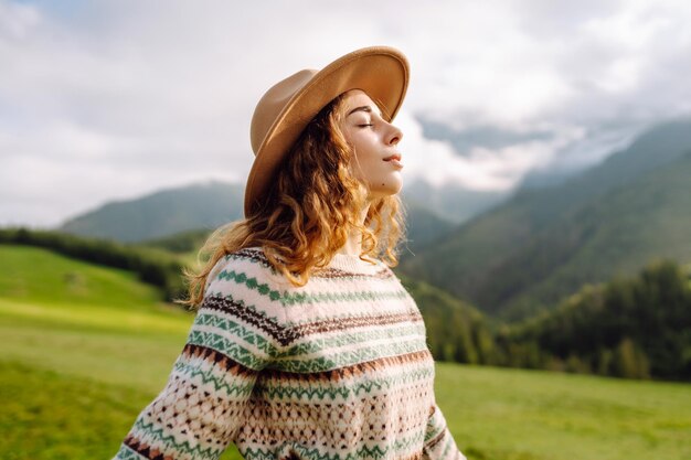 Mujer caminando a través del valle de hierba verde en el fondo grandes montañas concepto de descanso