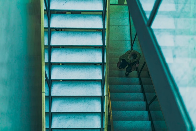 Mujer caminando en la vista de la escalera desde arriba