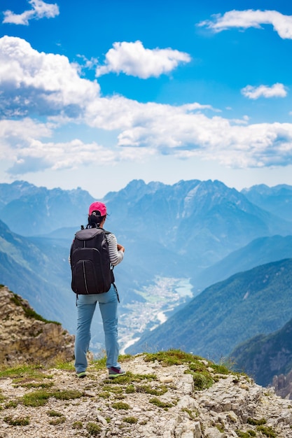 Mujer caminante de pie logrando la cima. Parque Natural Nacional Tre Cime En Los Alpes Dolomitas. Hermosa naturaleza de Italia.