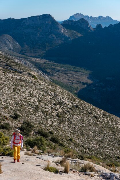 Mujer caminatas a lo largo de ridgecrest caminatas cuesta arriba El Divino montaña Alicante provincia Costa Blanca España