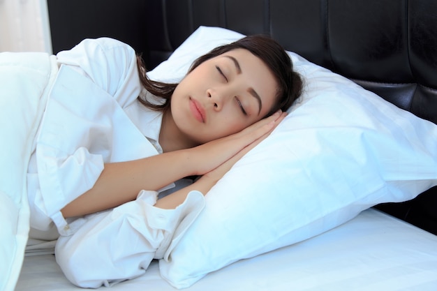 mujer en camisa blanca durmiendo en su dormitorio. concepto para saludable.