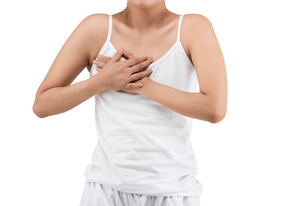 La mujer con una camisa blanca sosteniendo su pecho.