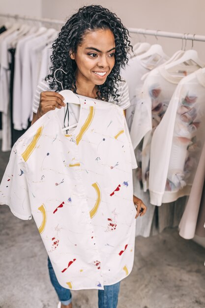 Mujer con camisa elegante en perchas