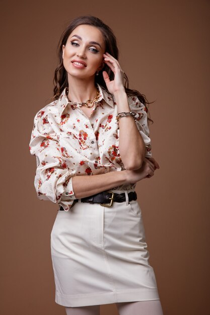 Mujer en camisa estampada falda corta blanca medias zapatos accesorios sobre fondo beige