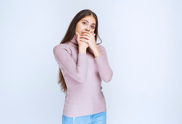 mujer con camisa morada parece asustada y aterrorizada.