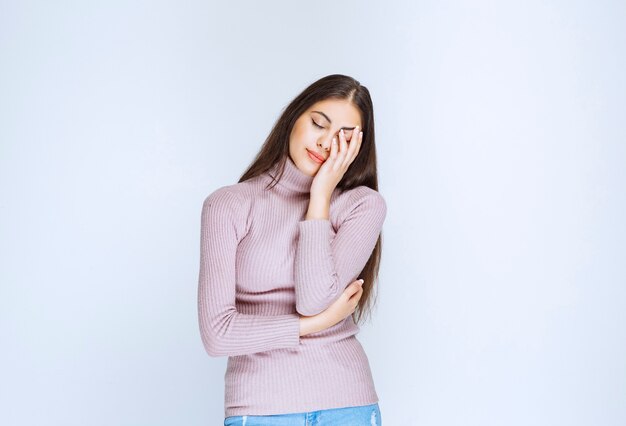 mujer con camisa morada tiene sueño o dolor de cabeza.