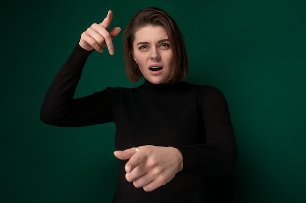 Foto mujer con camisa negra apuntando