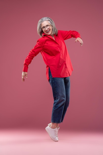 mujer, en, camisa roja, posición, en, ella, dedos de los pies