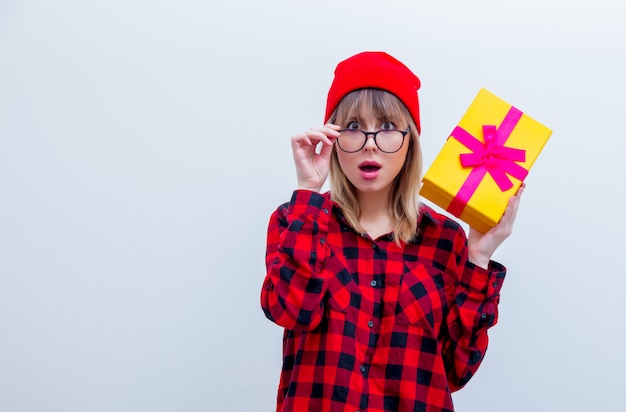 Mujer en camisa roja y sombrero con caja de regalo de vacaciones