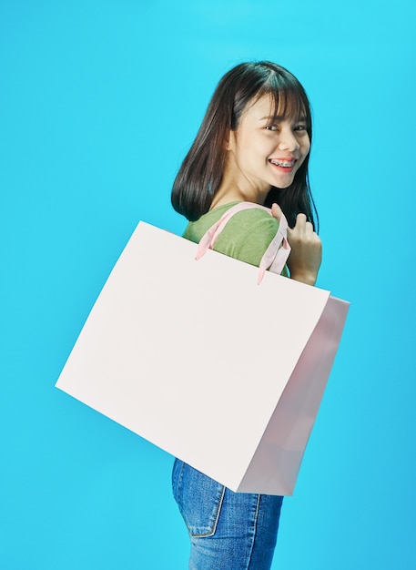 Mujer con camisas verdes con bolsas de compras