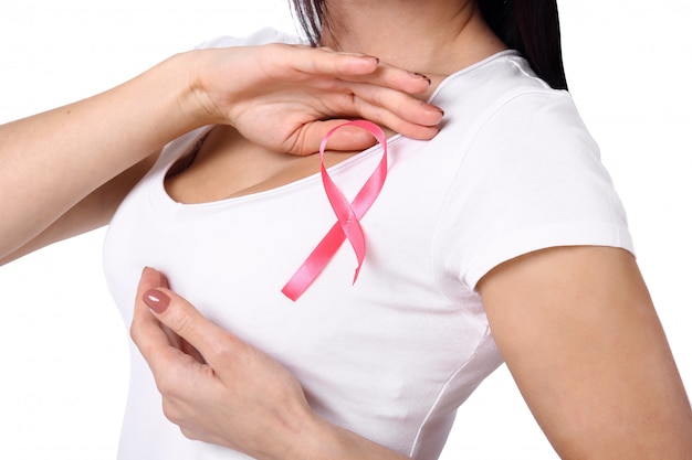 Mujer en camiseta blanca con cinta de concienciación sobre el cáncer de mama rosa.