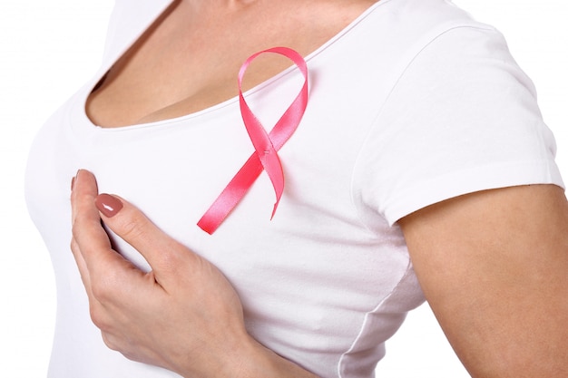 Mujer en camiseta blanca con cinta de concienciación sobre el cáncer de mama rosa.