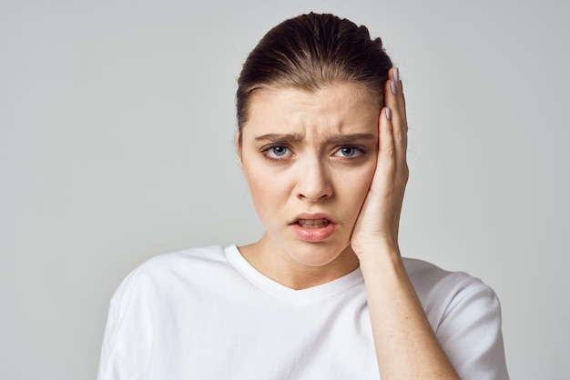 Mujer en camiseta blanca dolor de cabeza migraña depresión descontento negativo