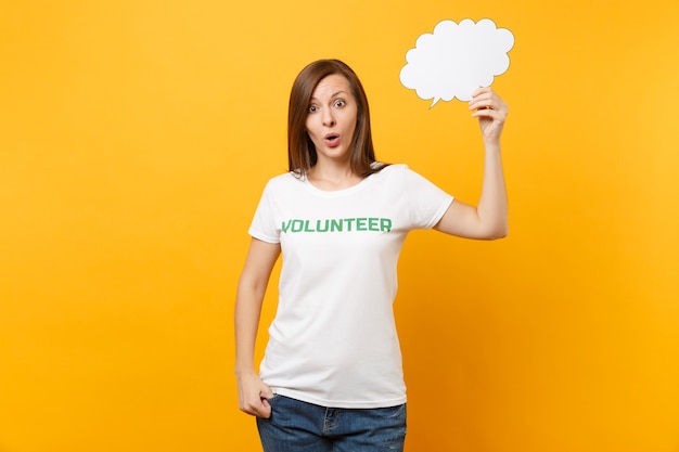 Mujer en camiseta blanca con inscripción escrita Voluntario de título verde mantenga en blanco vacío Diga el bocadillo de diálogo de nube aislado sobre fondo amarillo. La asistencia gratuita voluntaria ayuda al concepto de trabajo de gracia de caridad.