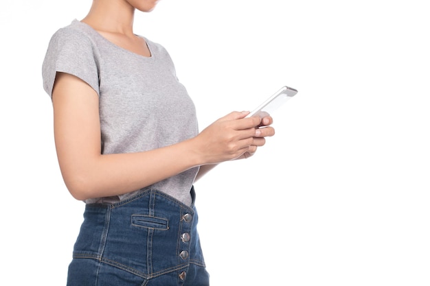 mujer con camiseta gris en blanco, jeans con teléfono inteligente móvil aislado en fondo blanco.