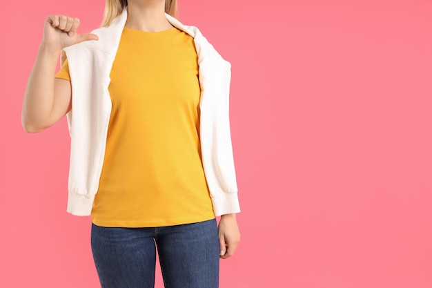 Mujer en camiseta naranja en blanco sobre fondo rosa