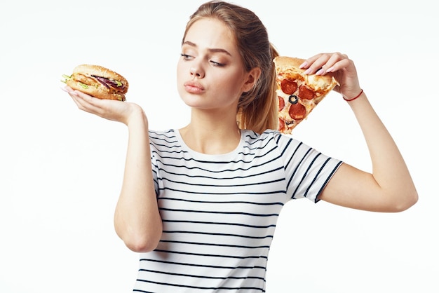 Mujer en camiseta a rayas comiendo pizza comida rápida dieta fondo claro