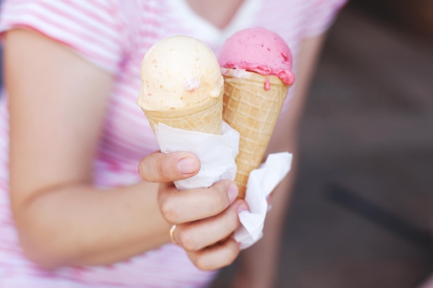Una mujer con una camiseta a rayas está comiendo helado en un clima caluroso