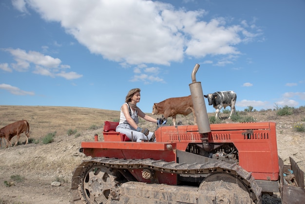 Mujer campesina conduciendo un tractor en el campo