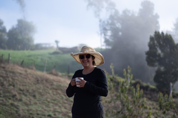 mujer campesina con taza de café en día nublado